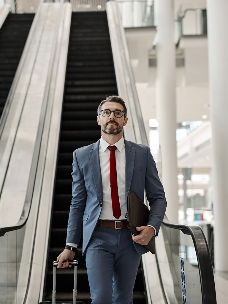 Business man riding down an escalator