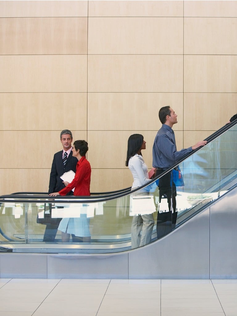 Business people using escalators